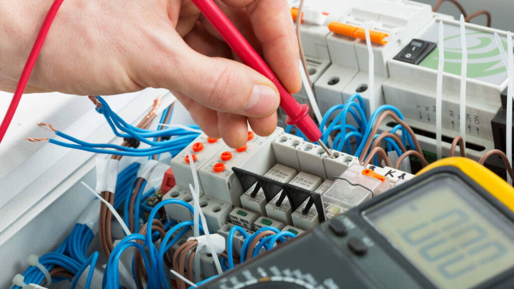 Engineer testing component with multimeter.