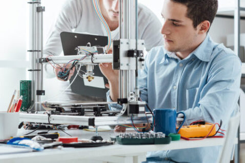 Two engineers using a 3D printer to create a bespoke design.