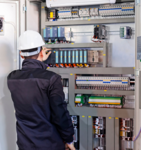 Engineer inspecting components in a control panel