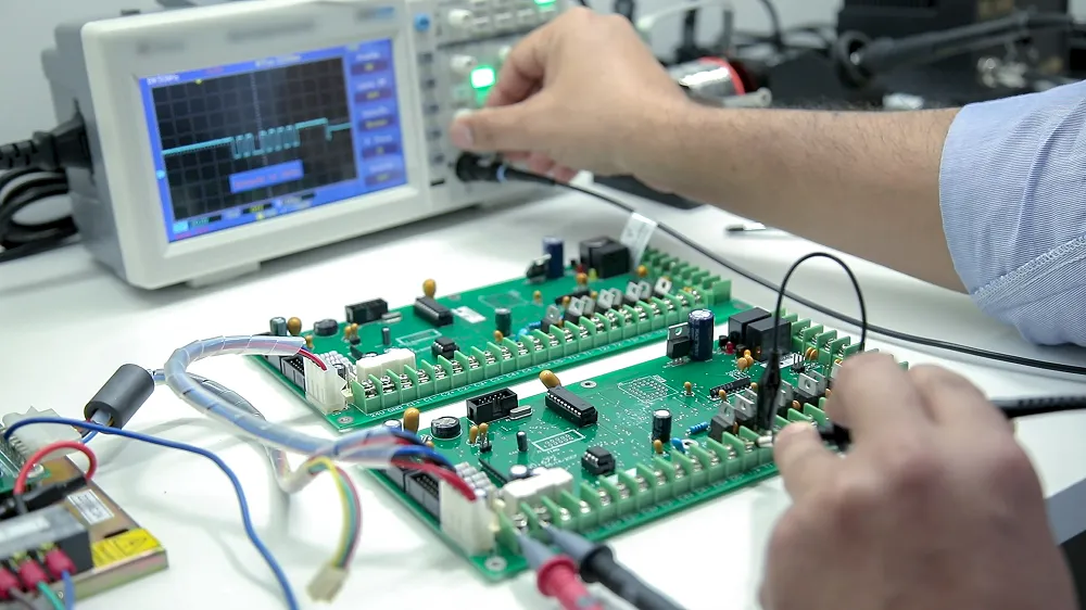 Engineer testing a circuit board with an oscilloscope.